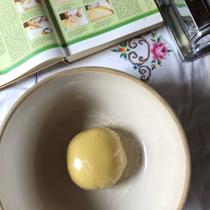 fresh egg pasta wrapped tightly in plastic wrap ready to be rested