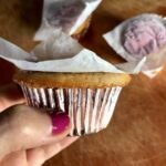 a cupcake with parchment needing to be removed so the whipped cream can be added