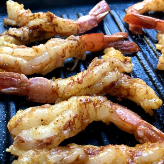 10 butterflied Argentinian Red shrimp seasoned and cooking on a grill pan