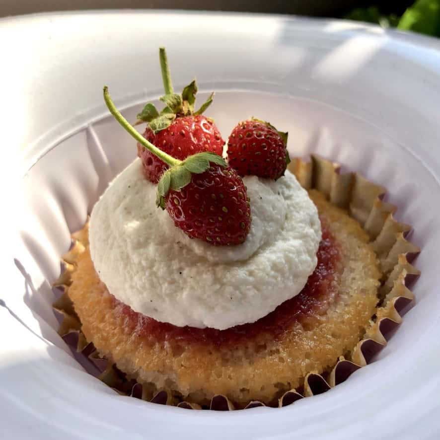 a single strawberry cupcake with strawberry gelée, strawberry vanilla bean whipped cream and baby wild Italian strawberries as garnish