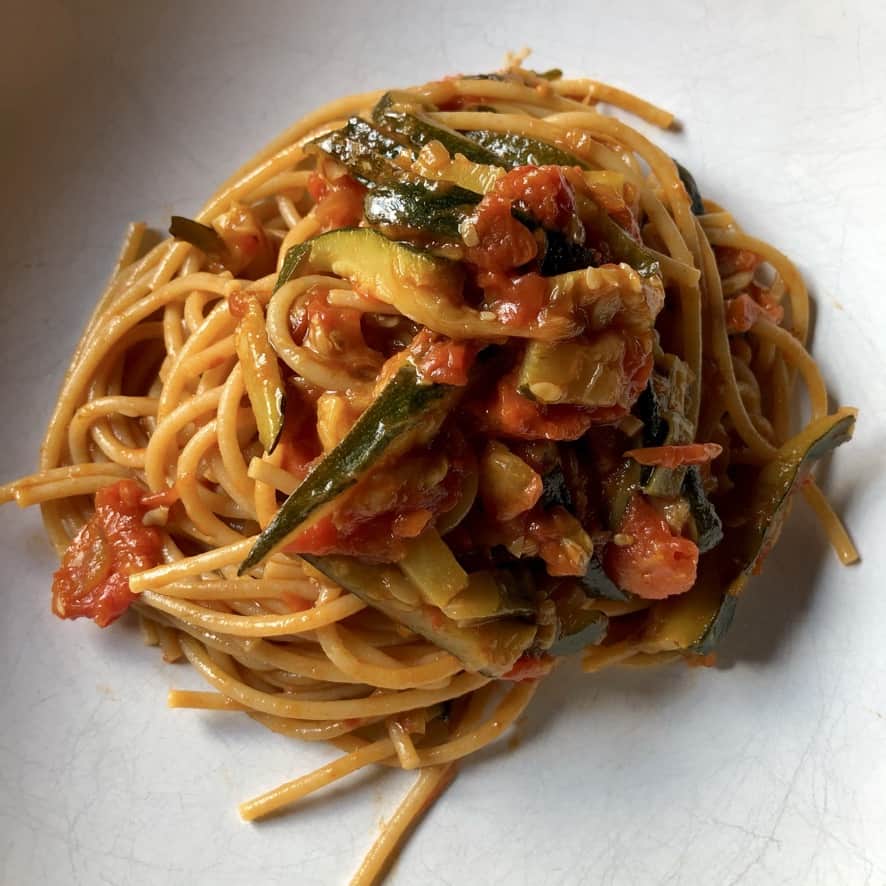 summer fresh tomato and zucchini pasta sprinkled with Grana Padano cheese