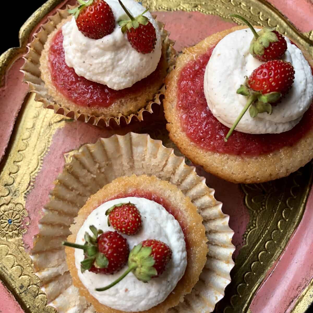 3 strawberry cupcakes with strawberry gelée, and strawberry vanilla bean whipped cream topped with baby wild Italian strawberries
