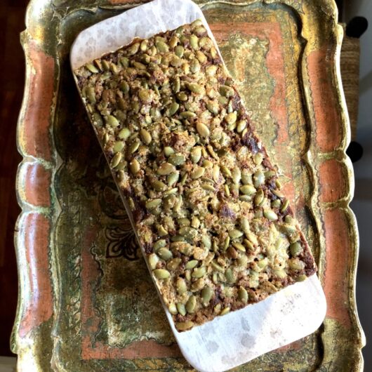 whole loaf of pumpkin spice banana bread cake with toasted pumpkin seed crunch on top
