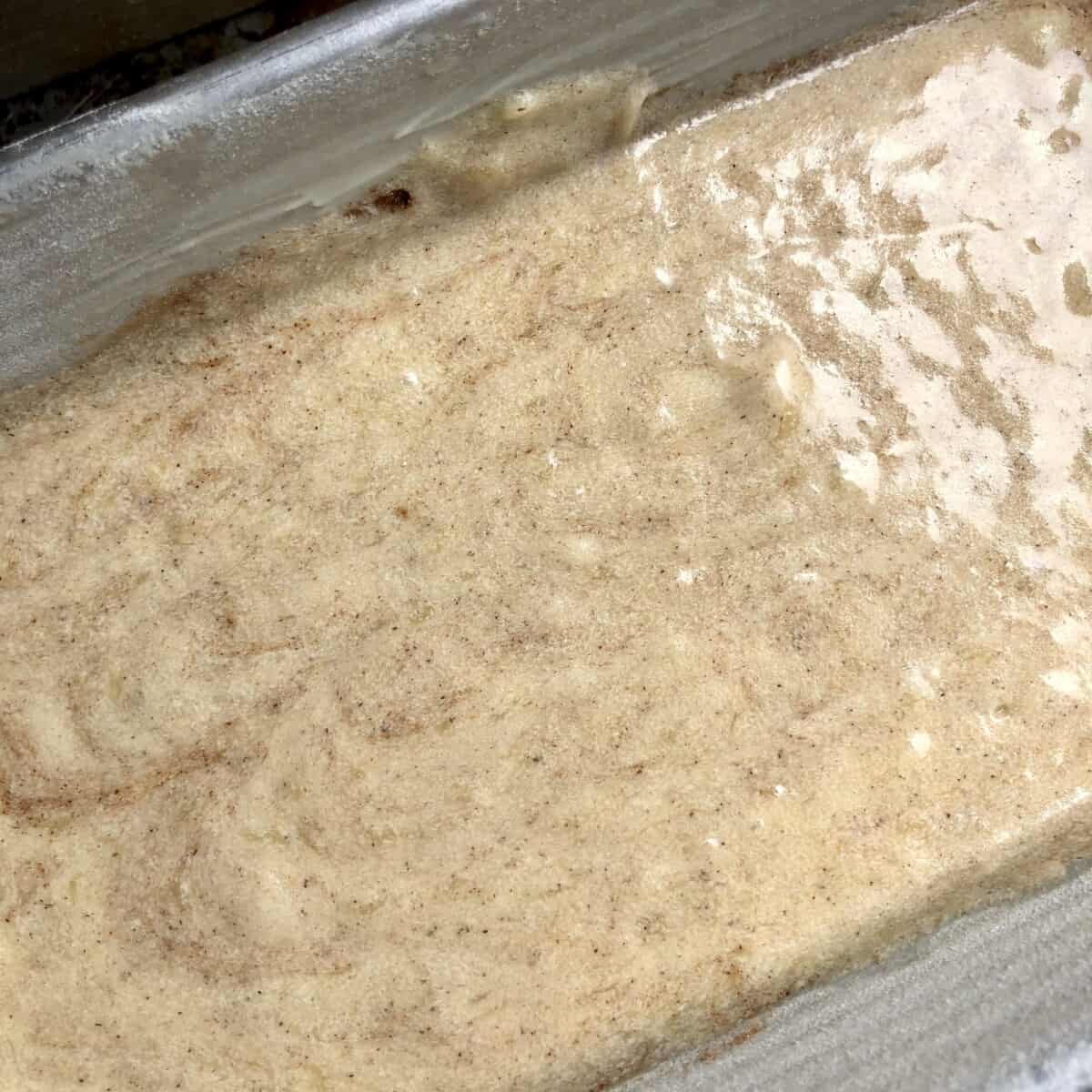 pumpkin spice banana bread batter in a prepared loaf pan