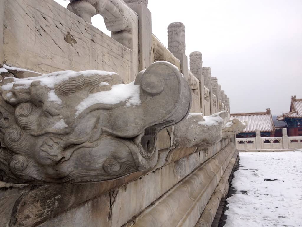 Sculptures jutting out of purely white gate at the Forbidden City in Beijing China