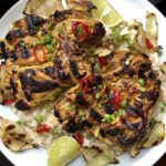 coconut lime chicken grilled beautifully and sitting atop a bed of fragrant coconut rice