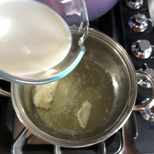 pouring milk into a pot with melting butter to heat it
