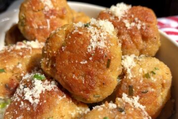 golden brown chicken and pork meatballs in a ceramic dish sprinkled with grated parm and chives