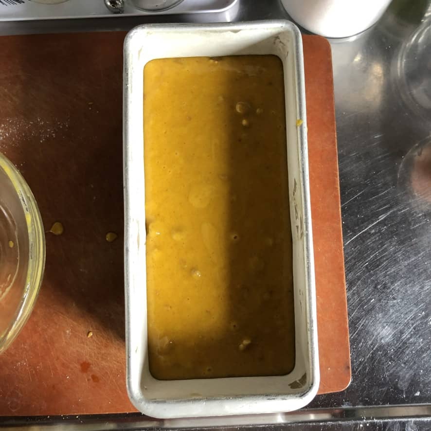 Pumpkin walnut bread batter in a prepared buttered and floured loaf pan. 

