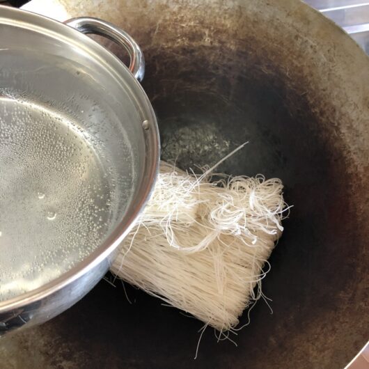 pouring boiling water over dried noodles