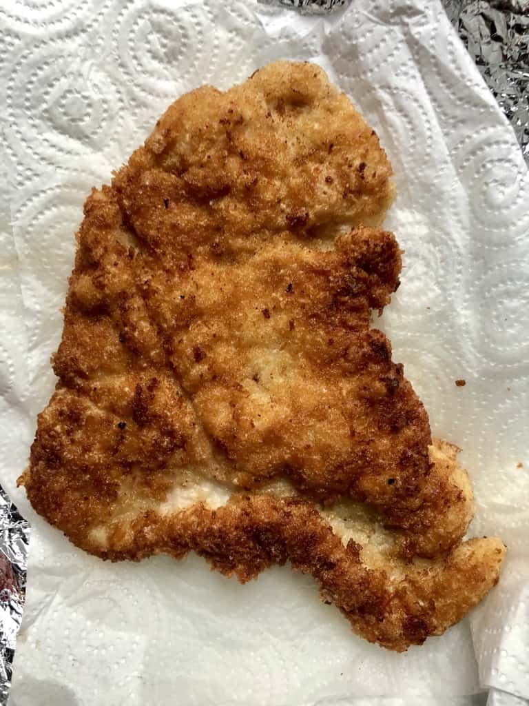 Just-Fried turkey breast cutlet on a paper towel-lined plate