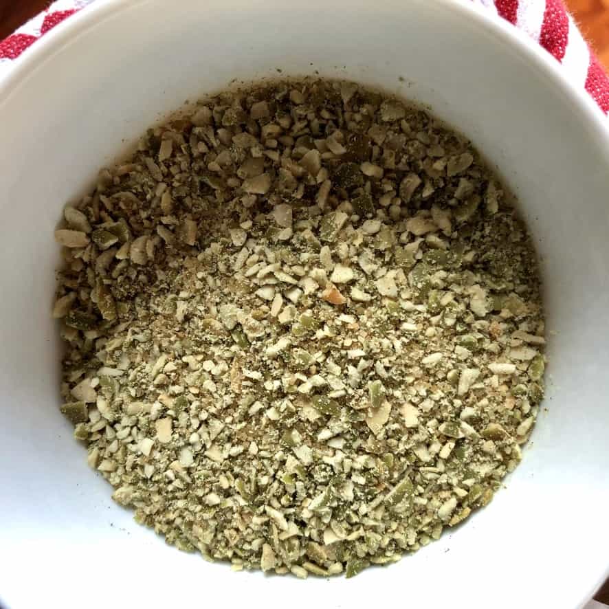 raw coarse sugar, pumpkin spice, and crushed toasted pumpkin seeds in a bowl after being combined