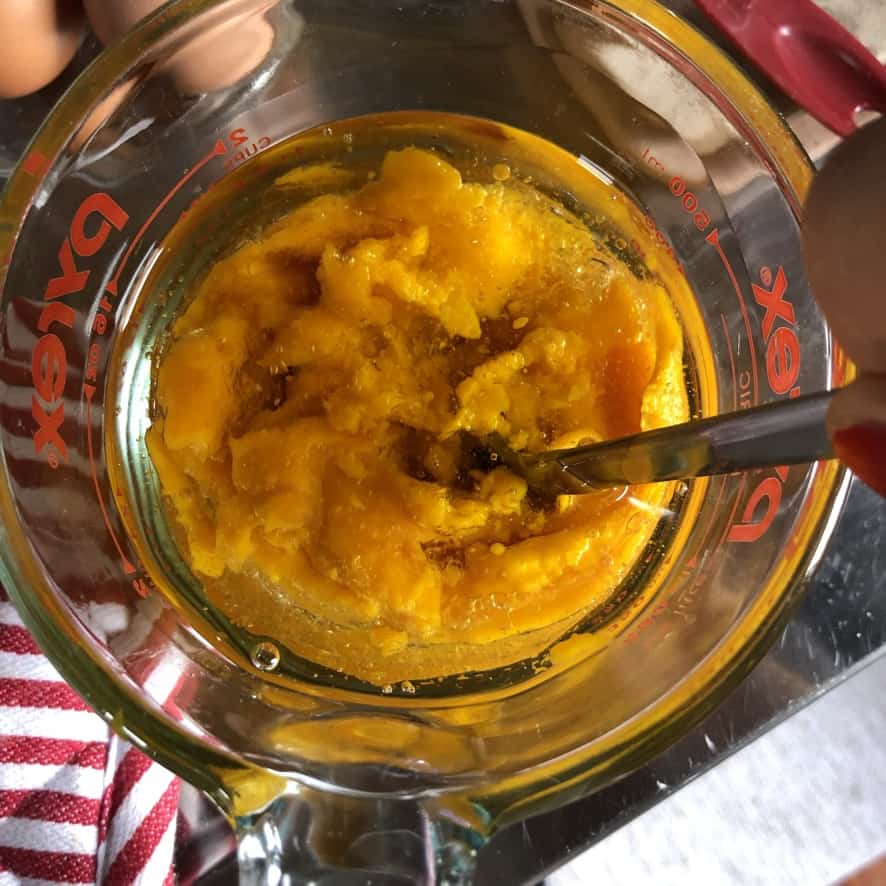 All the wet pumpkin muffin ingredients added to a glass pyrex mixing glass.