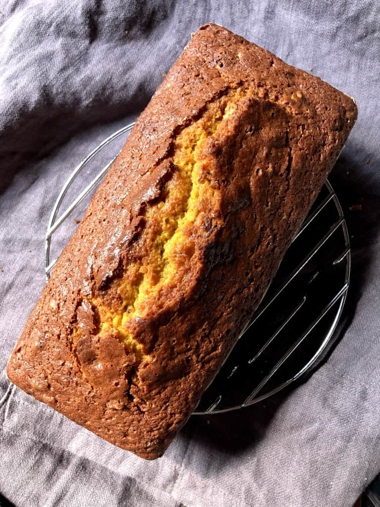 just baked golden brown pumpkin bread with a bakery style crevice through the middle