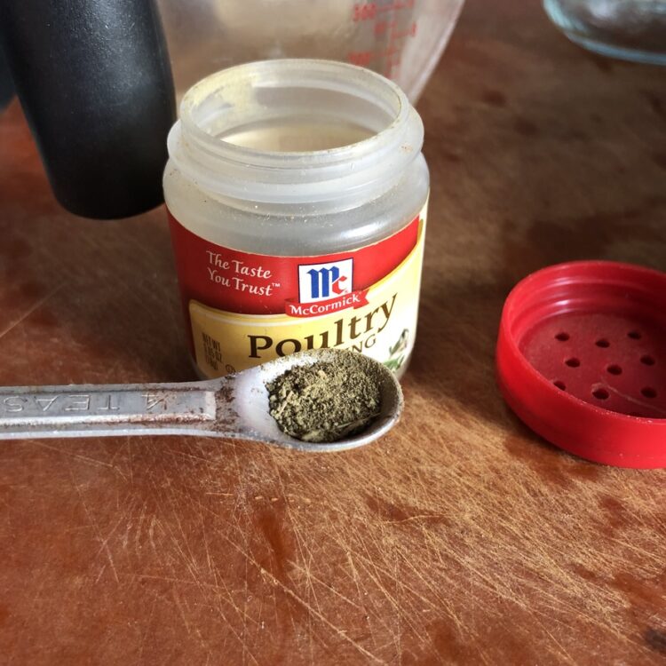 1/8 of a teaspoon of poultry seasoning next to a bottle of McCormick's poultry seasoning