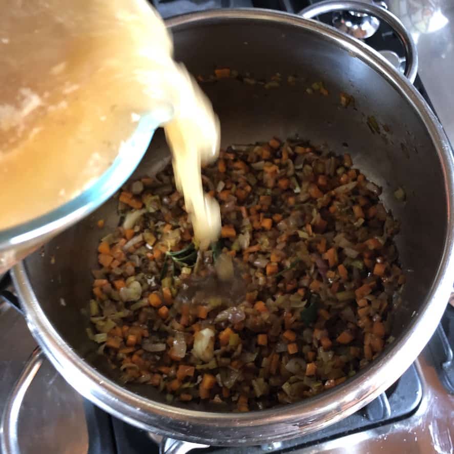 adding turkey stock to the sautéed vegetables
