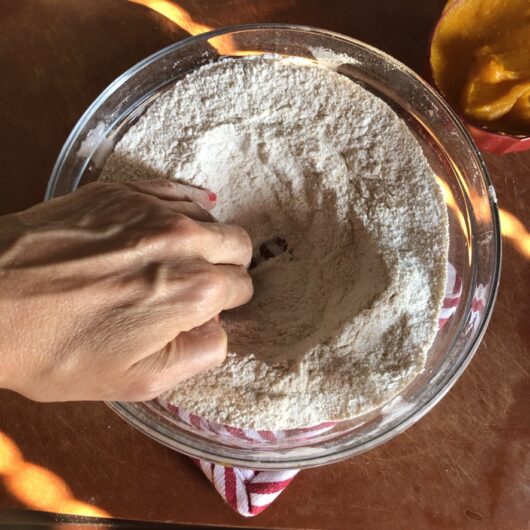 making a well in the whisked flour mixture