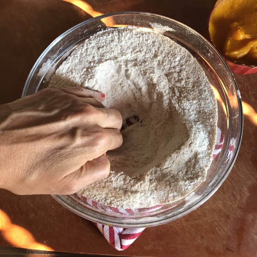 Making a well in the whisked flour mixture.