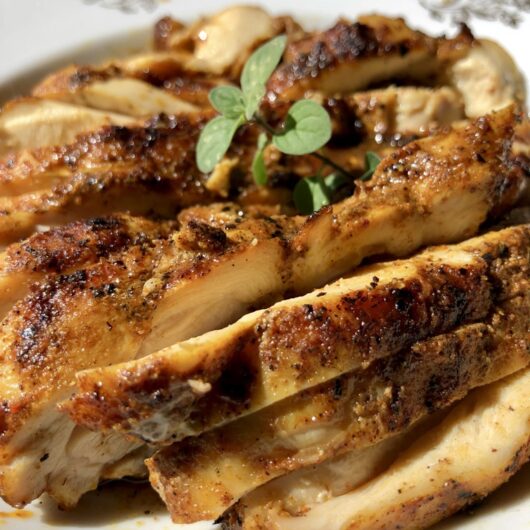 delicious golden brown grilled chicken shawarma with a sprig of fresh oregano on top