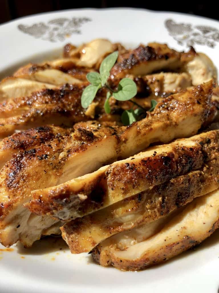 delicious golden brown grilled chicken shawarma with a sprig of fresh oregano on top