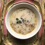 turkey and wild rice soup in a bowl on a ping and gold tray