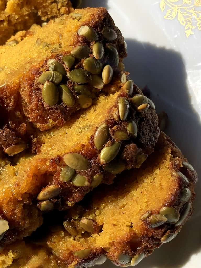 Slices of super moist pumpkin bread with toasted pumpkin seed topping. 
