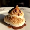a toasted ghost marshmallow s'mores on top of melted chocolate and halved oreo with the cream removed
