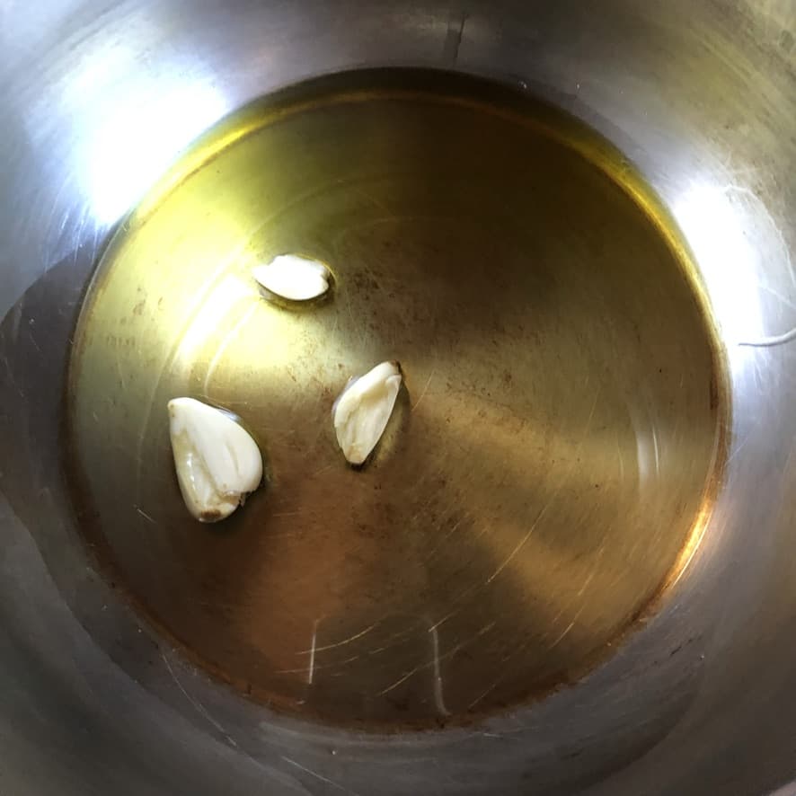 extra virgin olive oil with 2 large garlic cloves in a pressure cooker pot