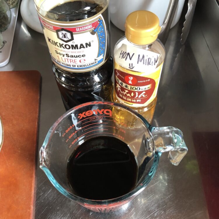a bottle of kikkoman regular soy sauce, Japanese Mirin, and a Pyrex glass measuring cup filled with the the soy-mirin ramen egg sauce