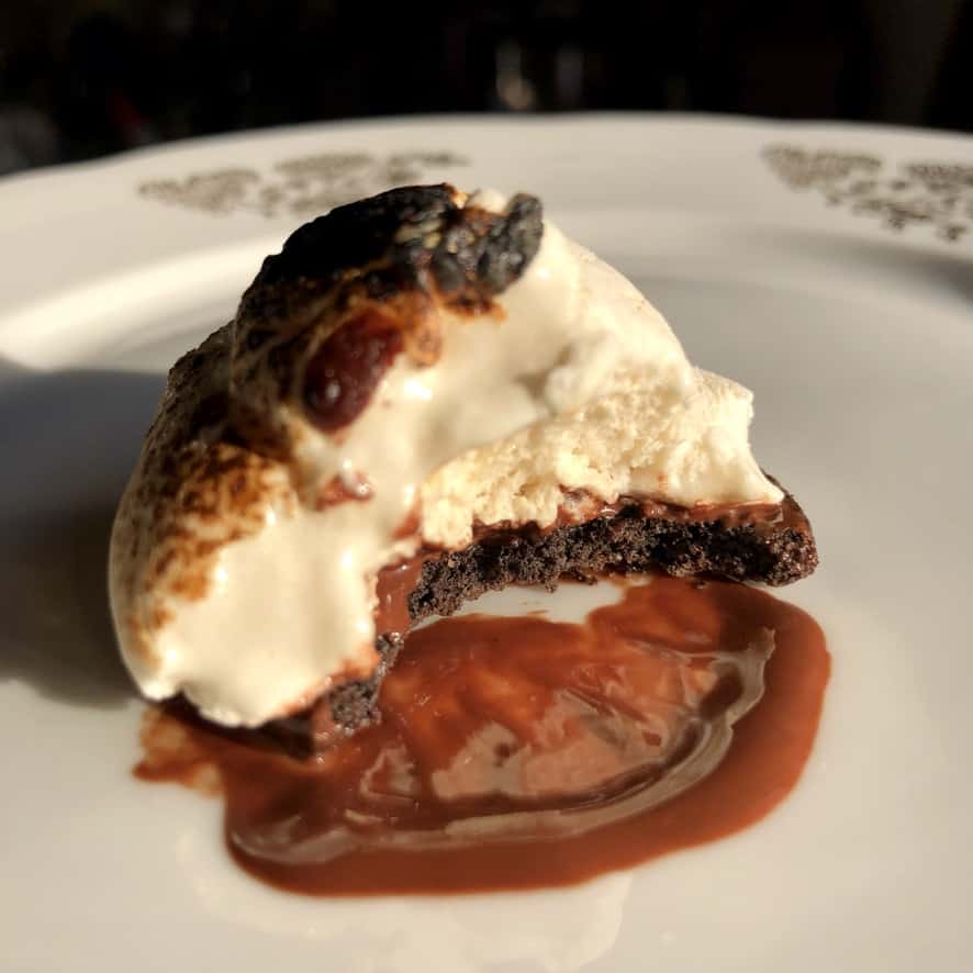 half eaten a toasted ghost marshmallow s'mores on top of melted chocolate and halved oreo with the cream removed