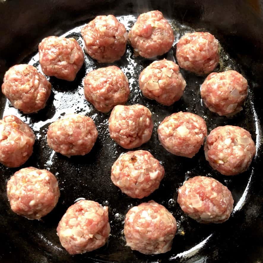raw swedish meatballs in a cast iron skillet