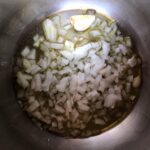 extra virgin olive oil with 2 large garlic cloves and chopped onions in a pressure cooker pot
