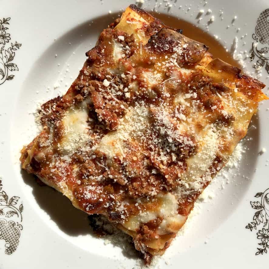 a large rectangle of lasagna sprinkled with grated cheese