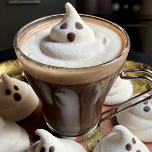 an Italian clear glass cappuccino mug filled with homemade hot chocolate and ghost marshmallow slowly melting on top