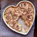heart shaped cake pan filled with day old baked cinnamon rolls still as fluffy and soft as ever with 3 rolls missing from the center and bottom