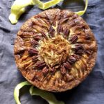 a whole apple cake with golden yellow apple peels around the top and bottom of the cake