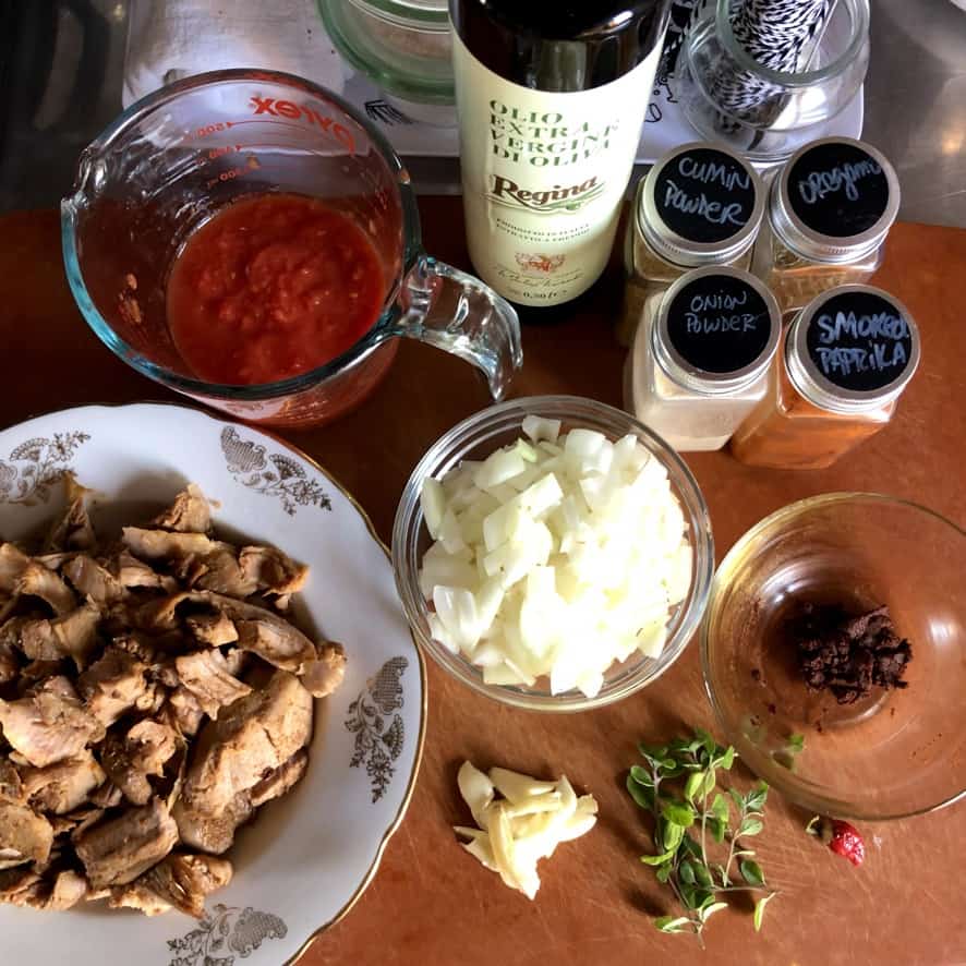 Ingredients to make the best tinga tacos on a cutting board.