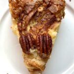 a slice of torta di mele apple cake with 2 crunchy pecans on top
