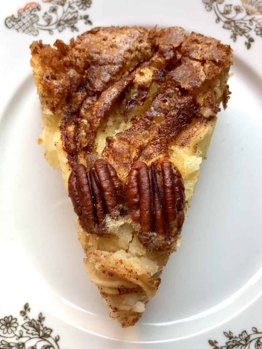 a slice of torta di mele apple cake with 2 crunchy pecans on top