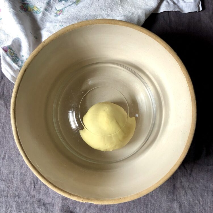 a glass bowl turned upside down to cover the egg pasta dough while it rests for 10 minutes