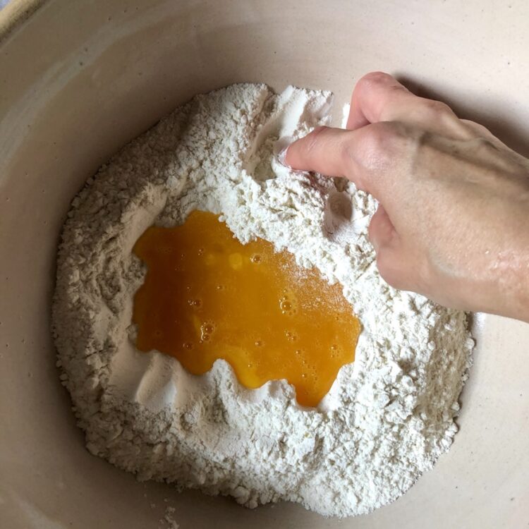 mixing together from the outside in, the flour into the eggs