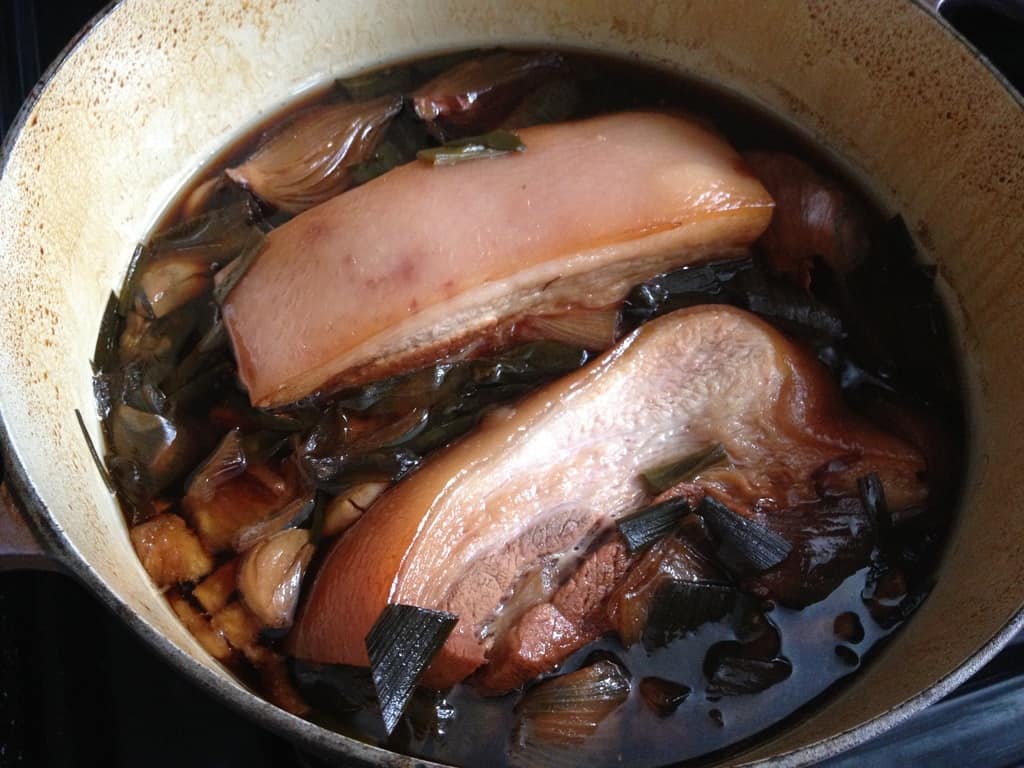 chasu braised pork belly not tied up in my dutch oven in two long rectangular pieces in the first hour or cooking