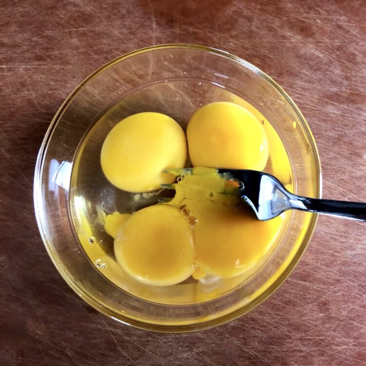 a fork whisking the eggs together