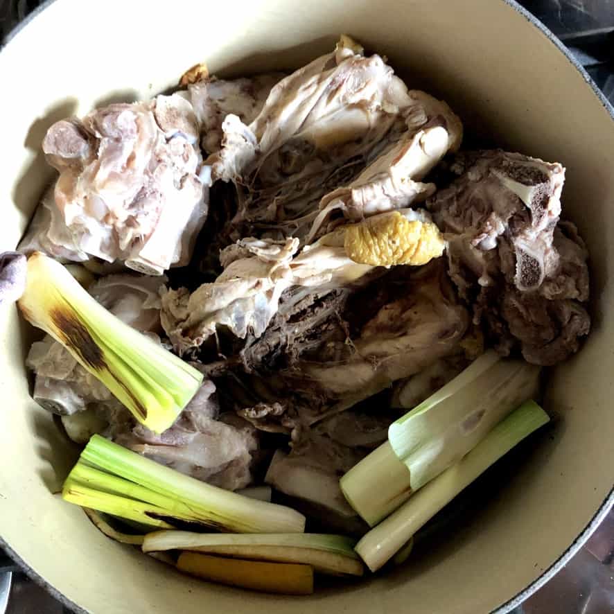 blanched bones added to the charred veggies in a dutch oven before covering them with water