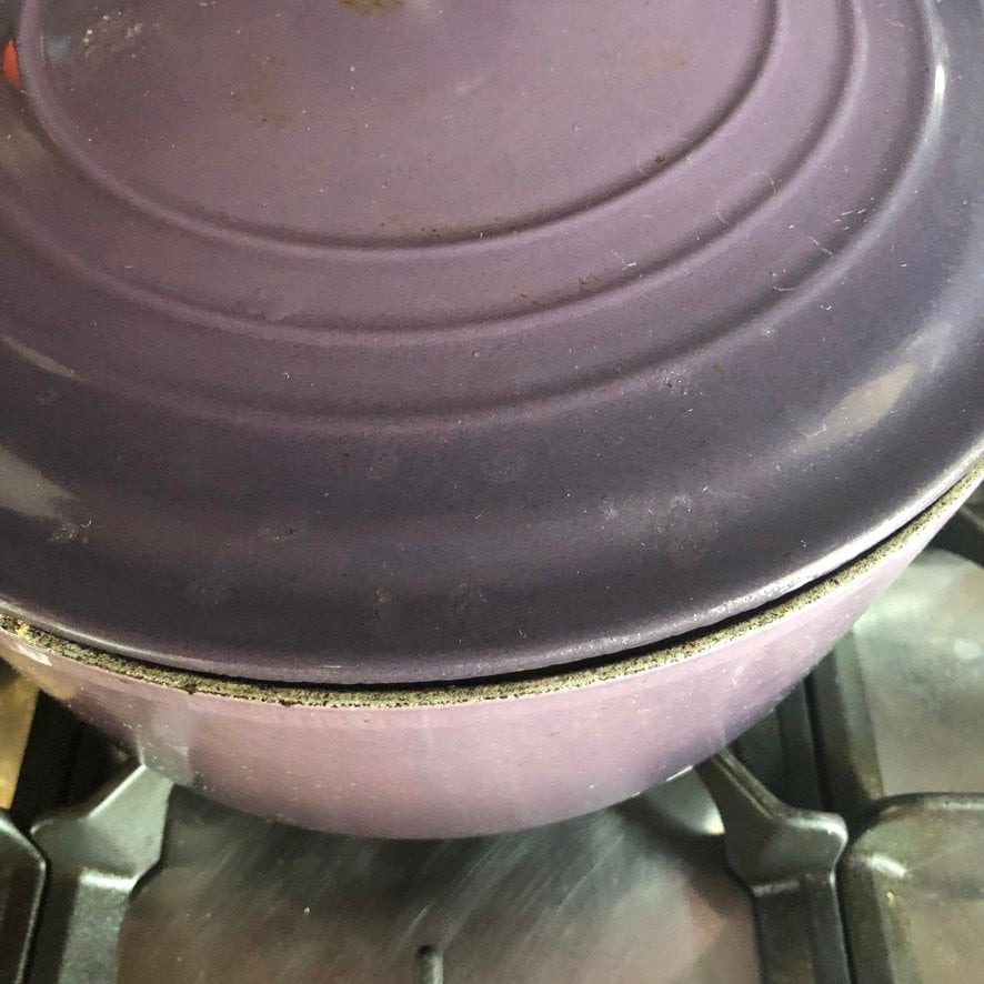 covering the dutch oven with a lid to allow it to cook undisturbed
