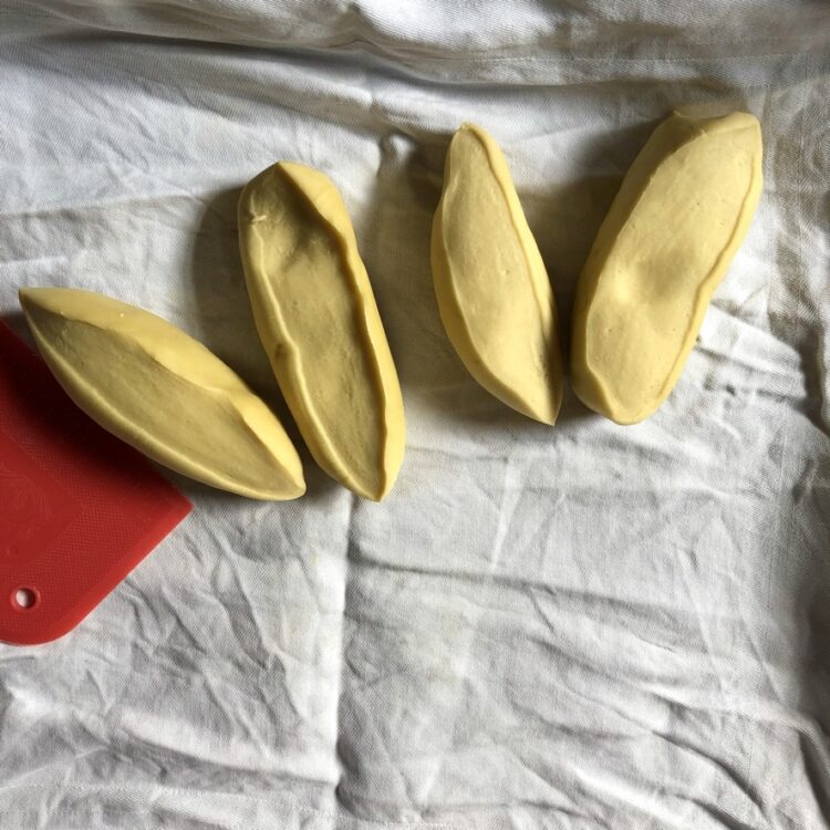 4 golden yellow pieces of egg pasta dough