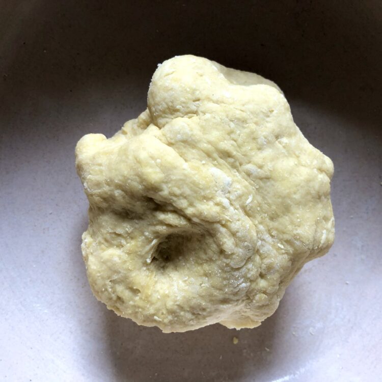 closeup of just mixed egg noodle dough when it has enough water and holds together and just before kneading it
