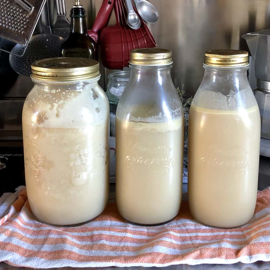 3 glass canning jars (large one) filled with opaque milky white tonkotsu broth