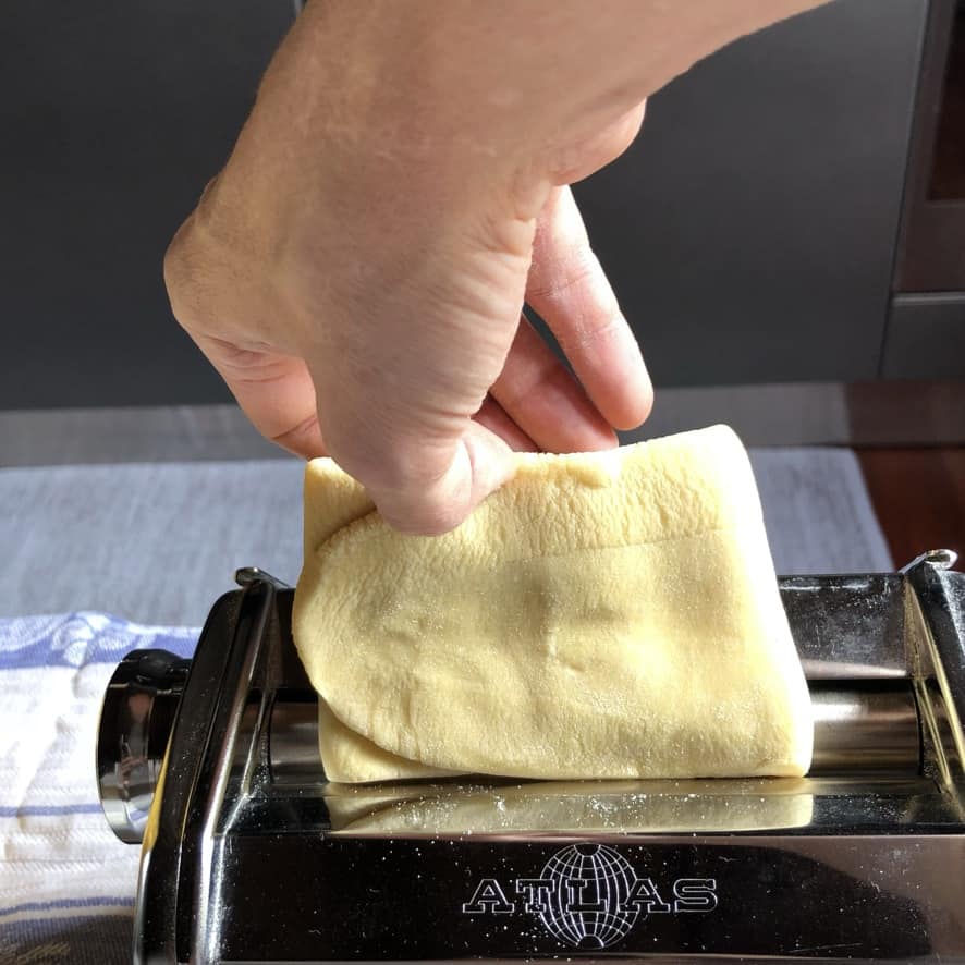 folded pasta piece going back through the widest setting on the pasta machine