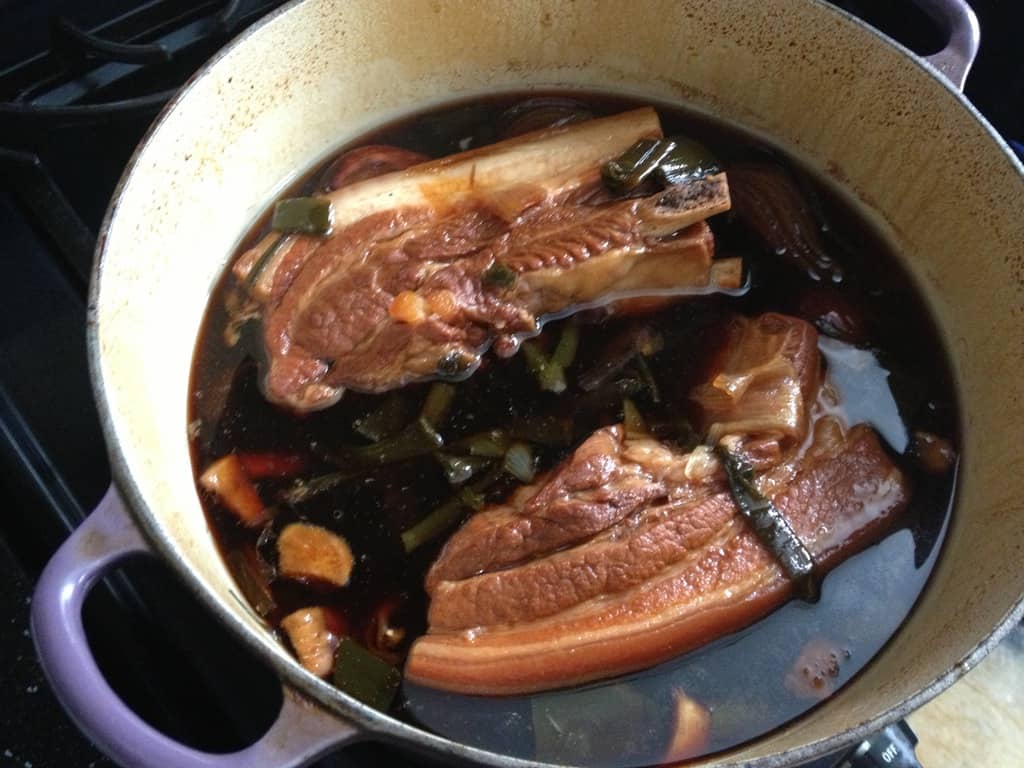 chasu braised pork belly not tied up in my dutch oven in two long rectangular pieces midway through cooking